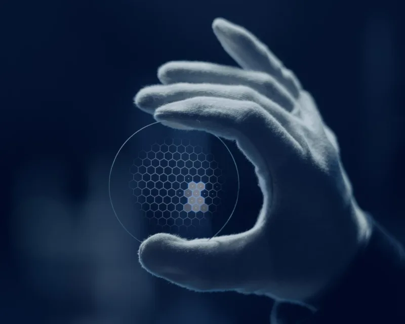 Essilor Varilux XR pro Lenses, gloved hand holding a Varilux XR series lens with a hexagonal pattern overlay